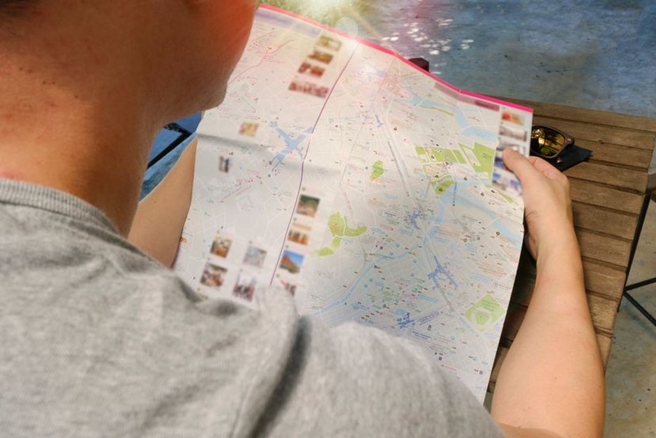 A traveller studying a folded city map during a day out.